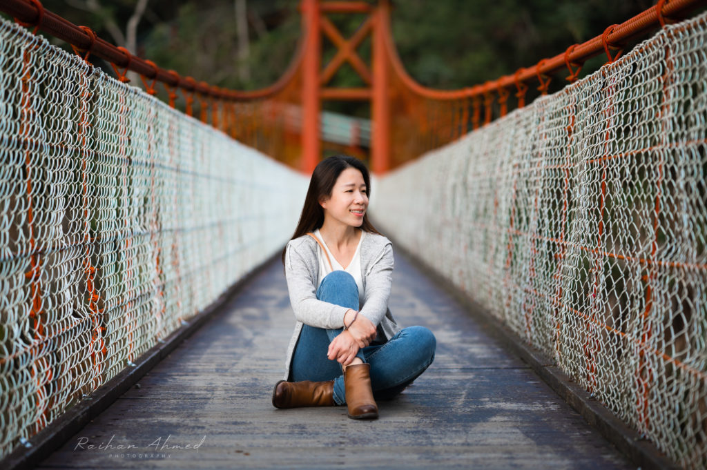 Woman sitting on suspenison bridge