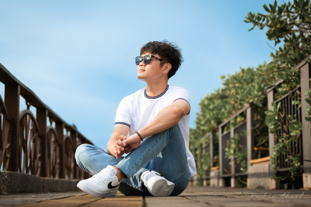 Man wearing sunglasses sitting on the floor looking at the sun