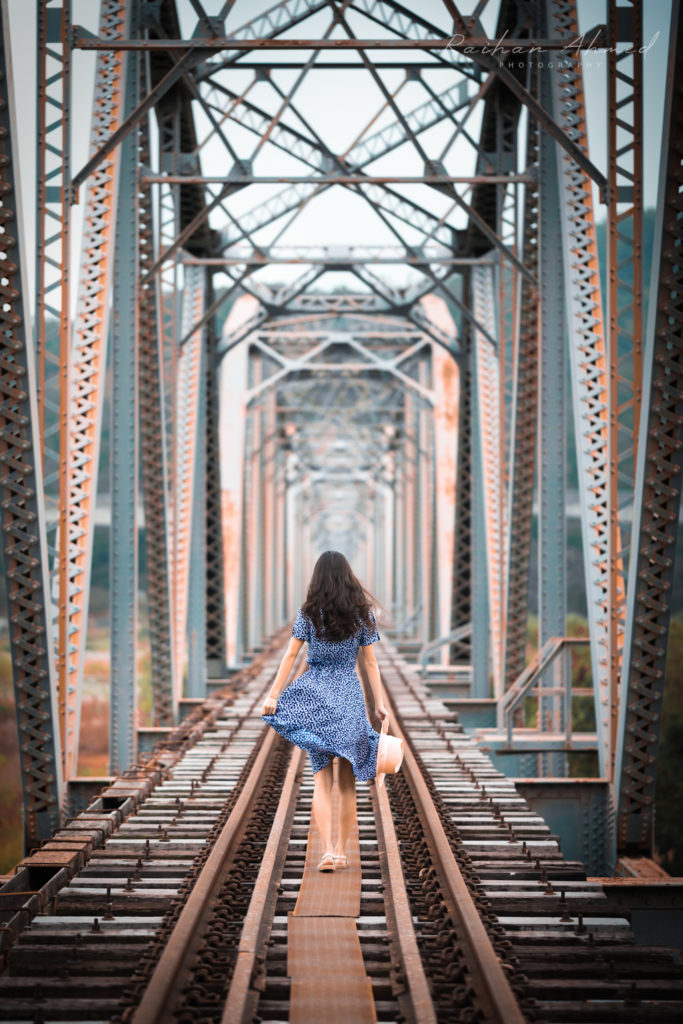 Woman on rail bridge walking away