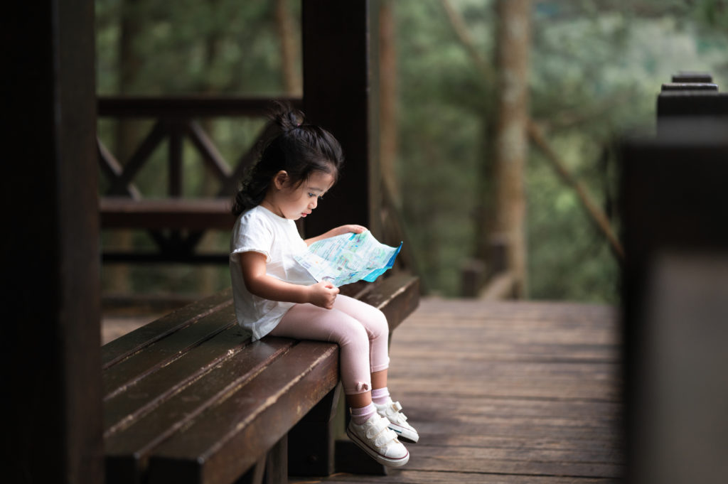 Photo of a toddler reading a map