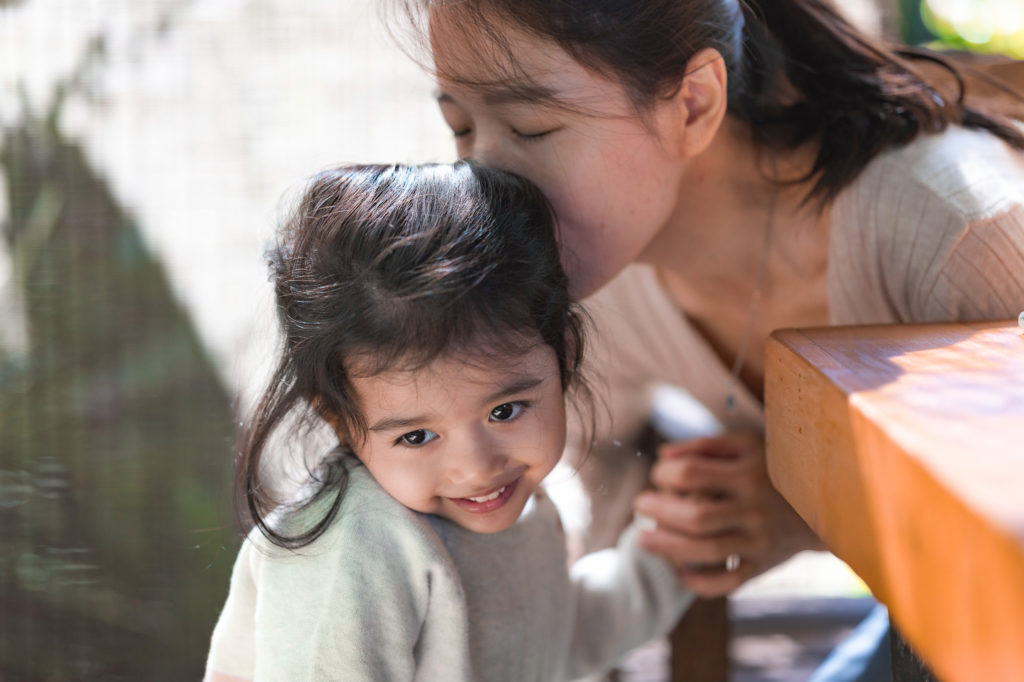Photo of a mother giving a gentle kiss to her daughter