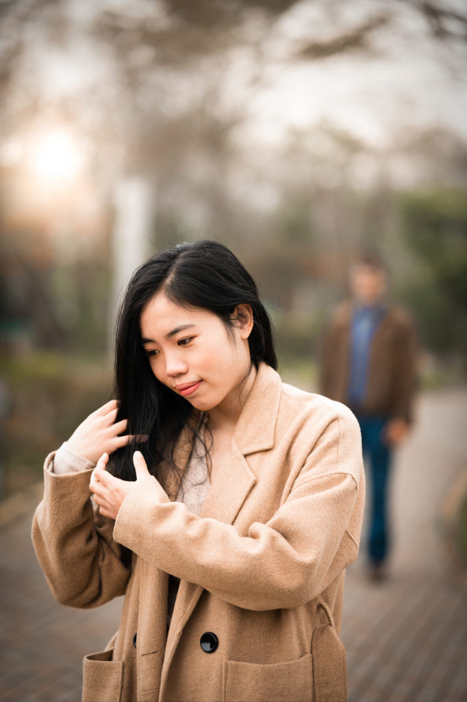 Photo of a woman smiling with her boyfriend in the background
