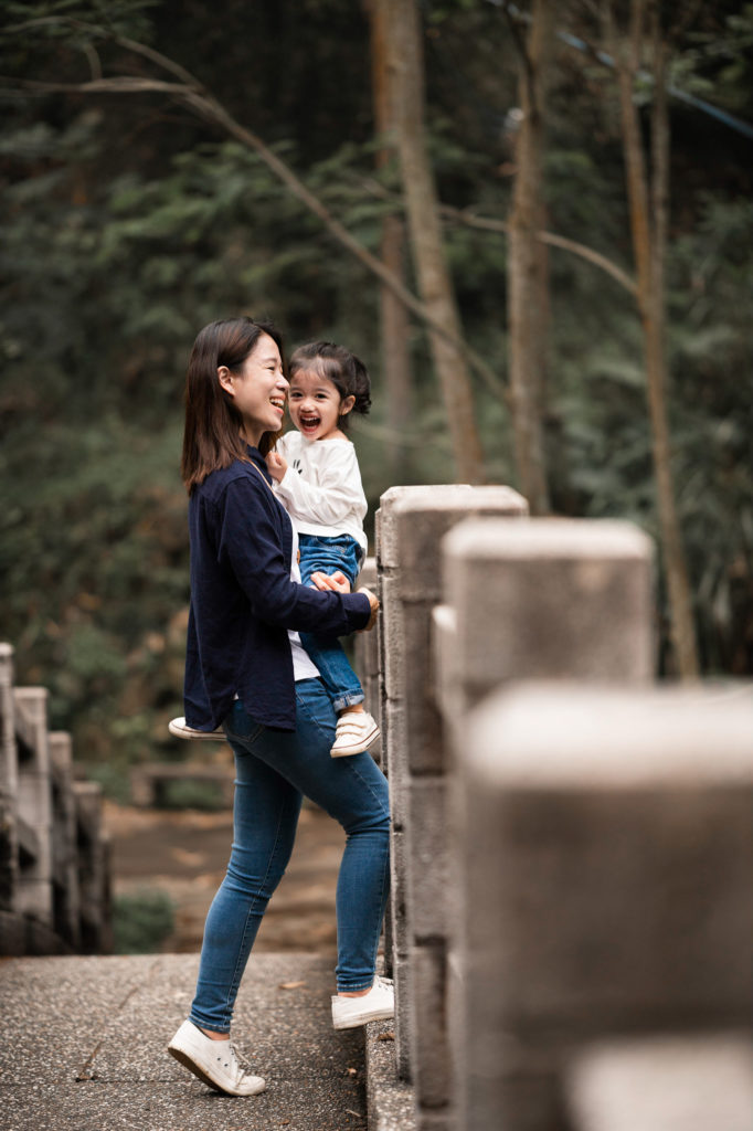 Photo of a mother and daughter happy on a bridge
