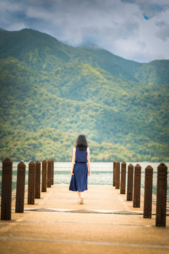 Woman on jetty with mountain and lake view