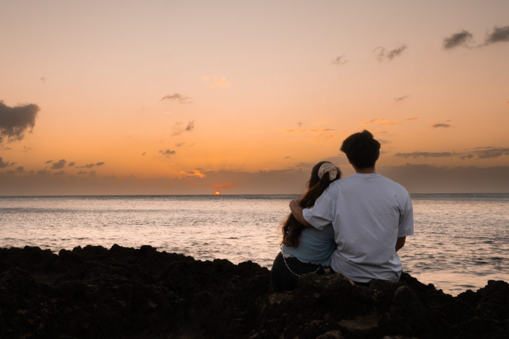 Couple looking at ocean sunset